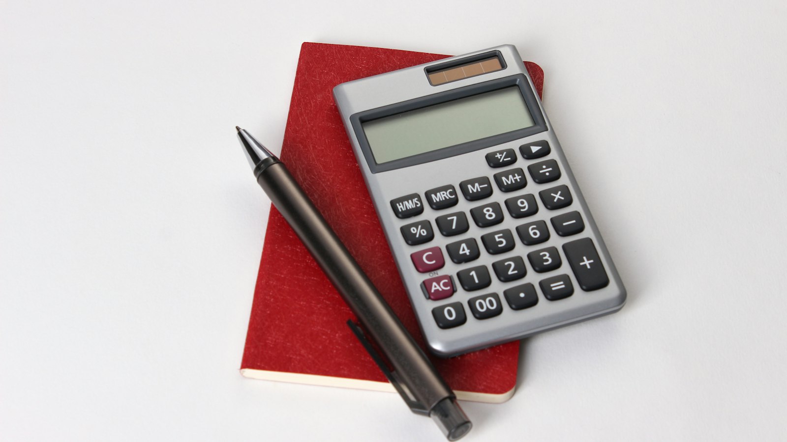 A calculator and pen on a desk